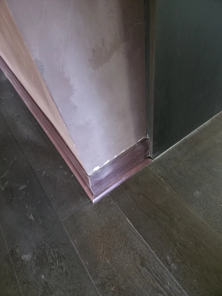 Dust along a painted wall and skirting before cleaning