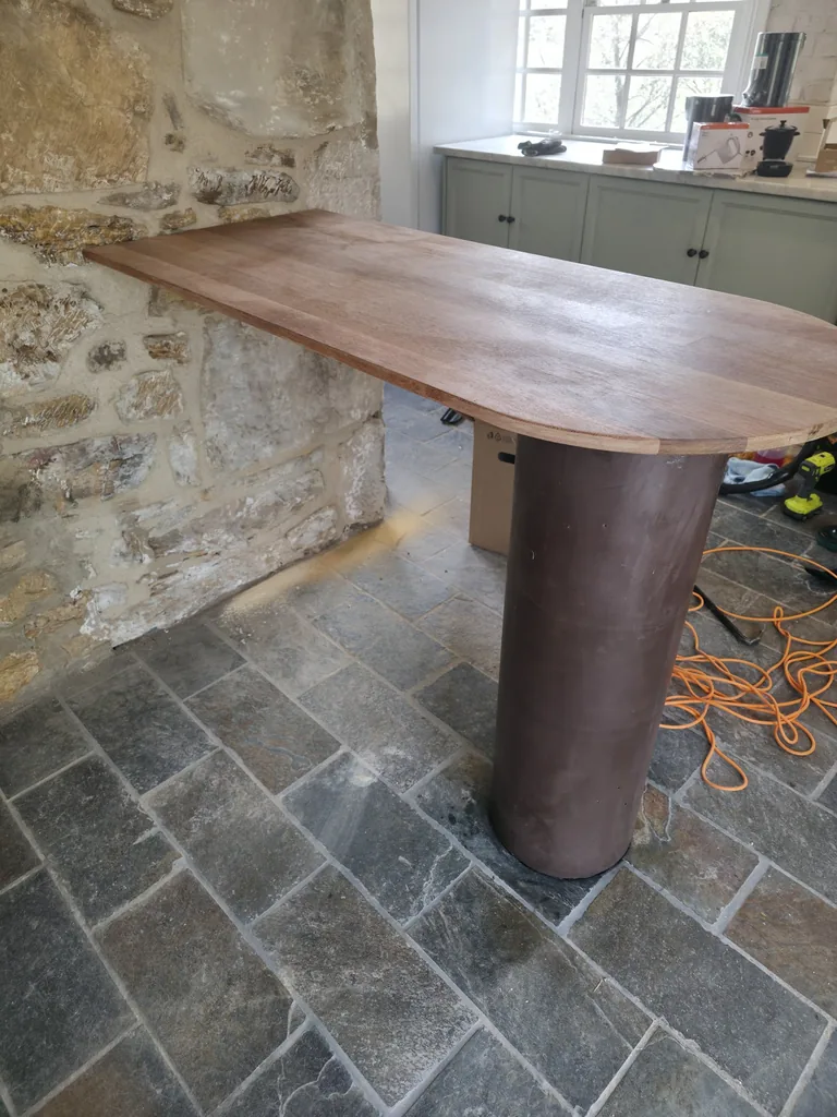 Stone kitchen floor and rounded timber table