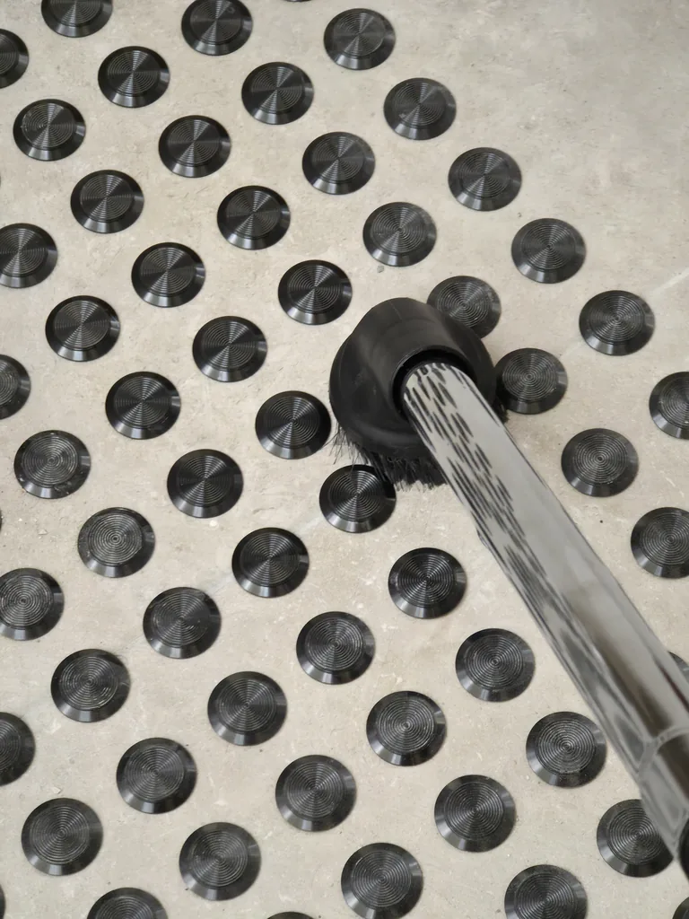Vacuum nozzle cleaning between tactile studs on the landing